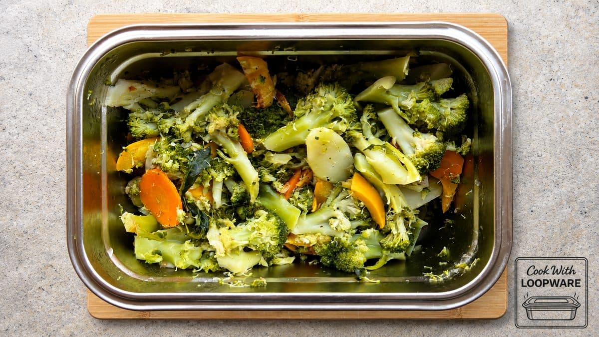 Broccoli, courgette and carrot cooked in a Loopware stainless steel container on the hob