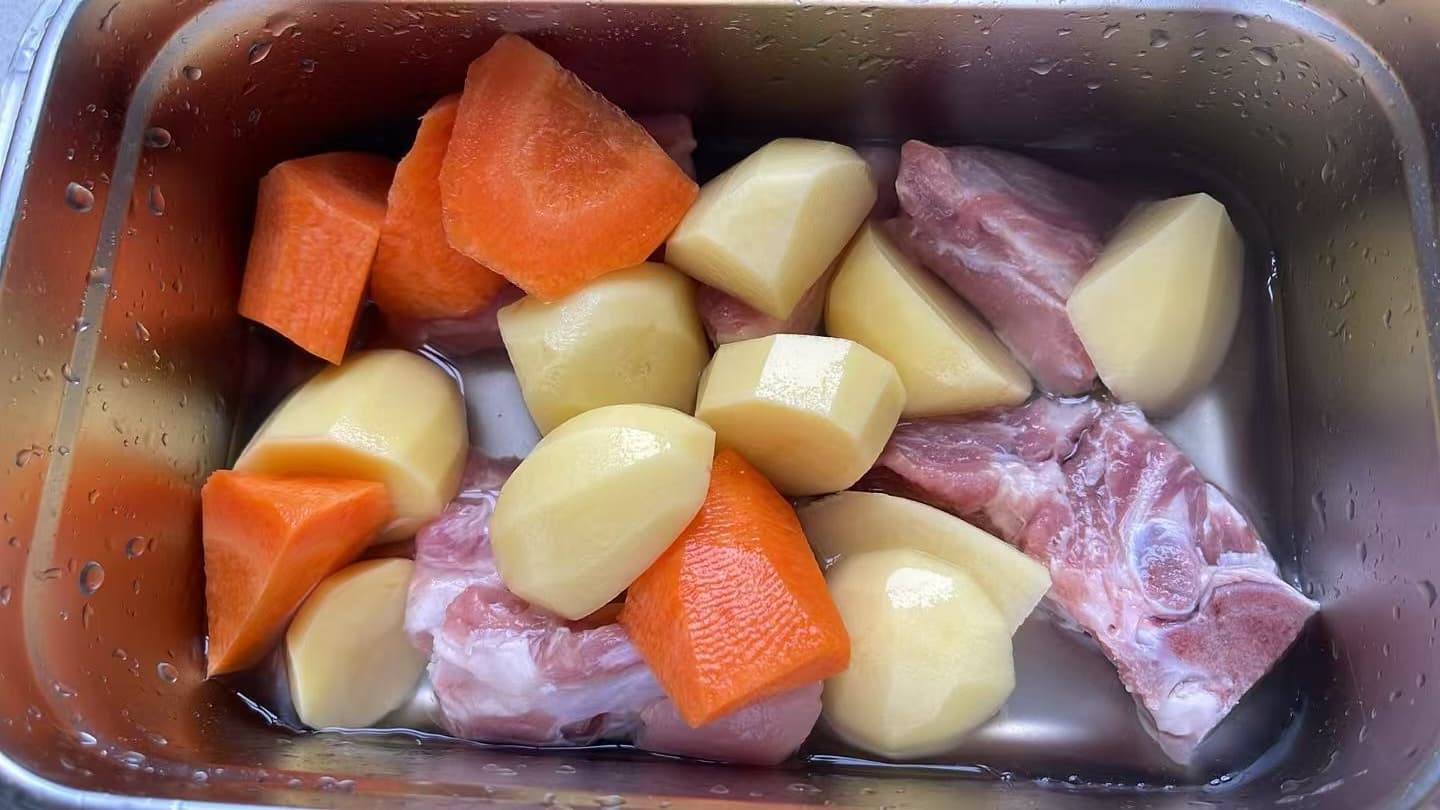Pork rib, carrot and potato stew simmering in a Loopware stainless steel cooking container